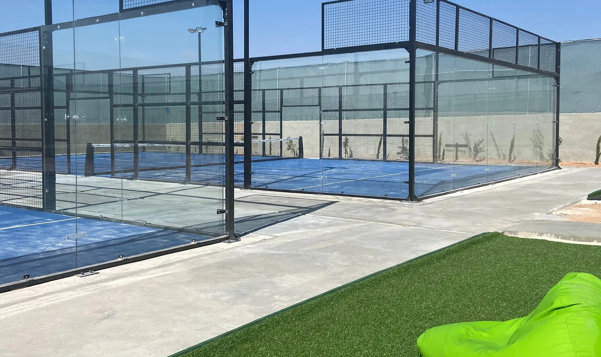 The outdoor courts by day, with a lawn and beanbag lounge courtside